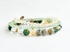 Set of beaded bracelets with green, white, and gold beads on a white background