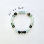 Beaded bracelet with various colored beads on a white background, featuring the text 'All is Well'.