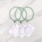 green beaded bracelets with matching cards on a marble surface galentine valentine bracelet bundle