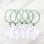green beaded bracelets with matching cards on a marble surface galentine valentine bracelet bundle