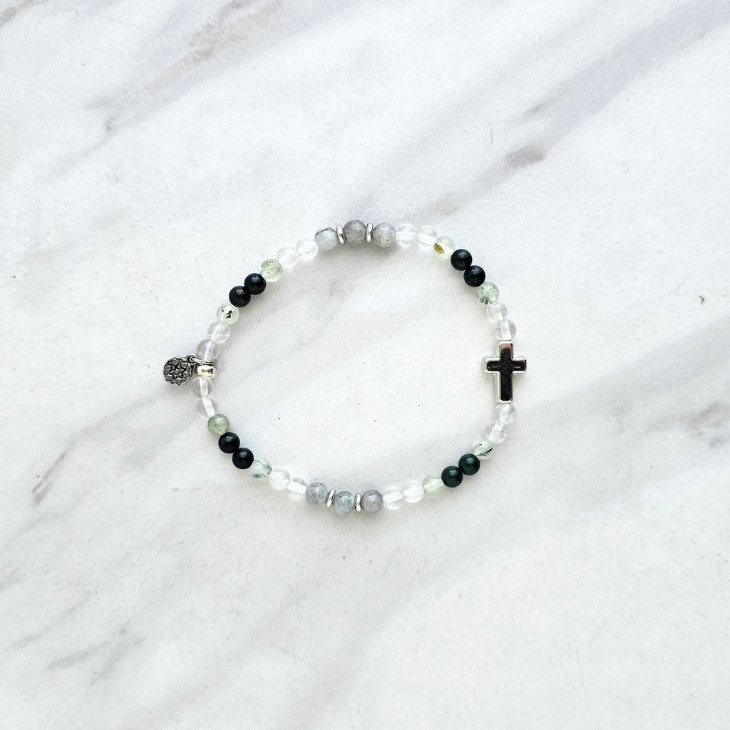 Christian Bracelet with beads and  silver colored cross on a marble background with Psalm 46:10 Be still and know