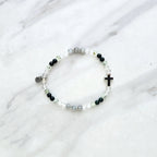 Christian Bracelet with beads and  silver colored cross on a marble background with Psalm 46:10 Be still and know