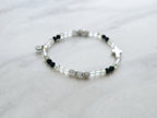 Christian Bracelet with beads and  silver colored cross on a marble background with Psalm 46:10 Be still and know