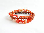 Stack of colorful beaded bracelets on a white background