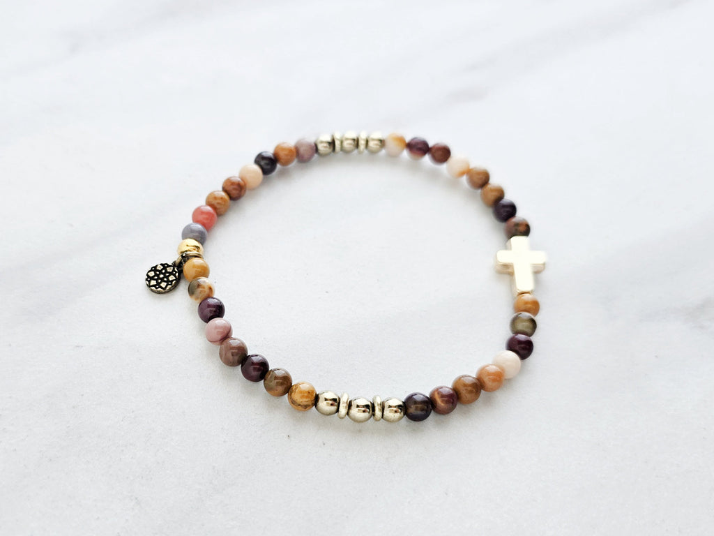 Christian Beaded bracelet with golden cross charm on a white background, featuring a quote from Matthew 6:34. stress and anxiety relief