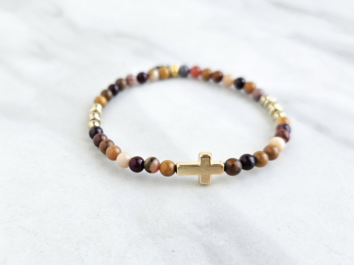 Christian Beaded bracelet with golden cross charm on a white background, featuring a quote from Matthew 6:34. stress and anxiety relief