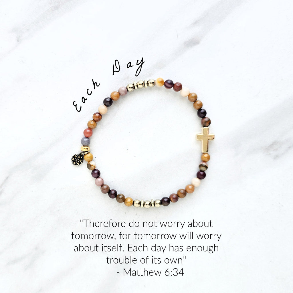 Christian Beaded bracelet with golden cross charm on a white background, featuring a quote from Matthew 6:34. stress and anxiety relief