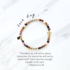 Christian Beaded bracelet with golden cross charm on a white background, featuring a quote from Matthew 6:34. stress and anxiety relief