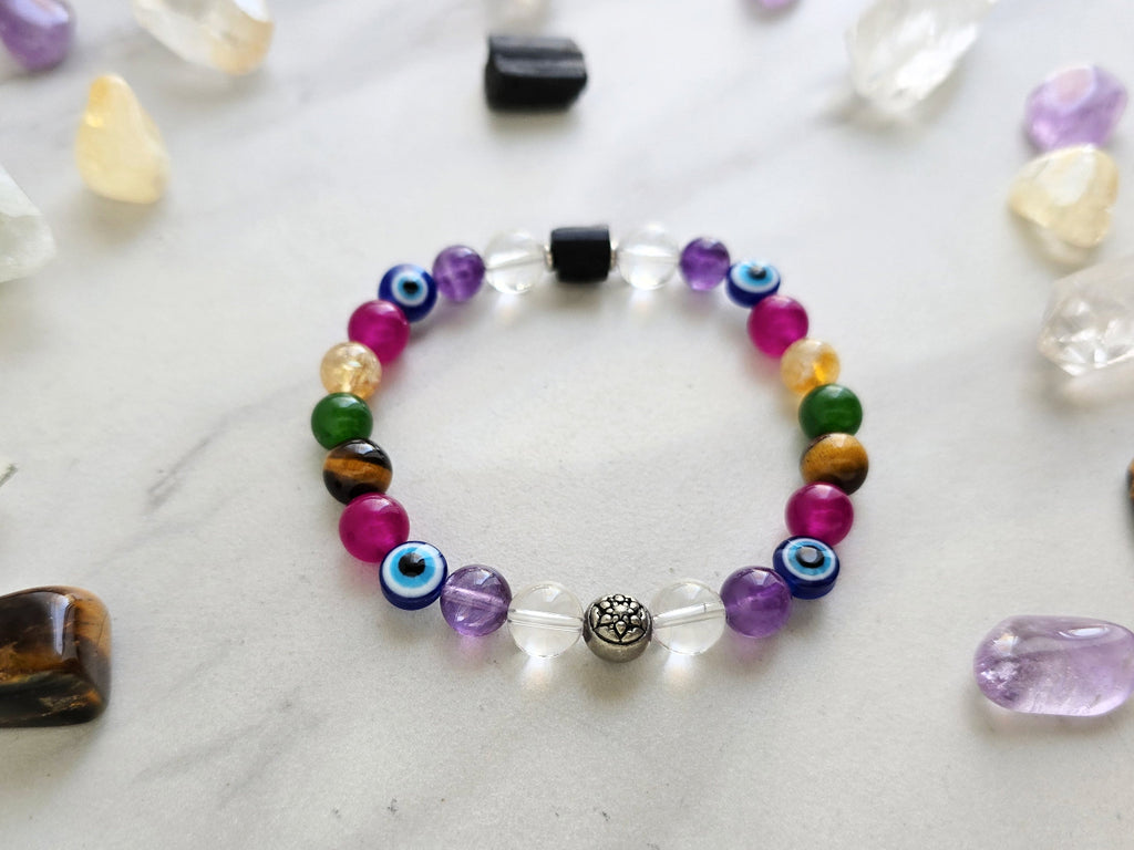 Colorful beaded bracelet on a white surface with crystals and text about collaboration between Ghost Sister and Moxie Malas.