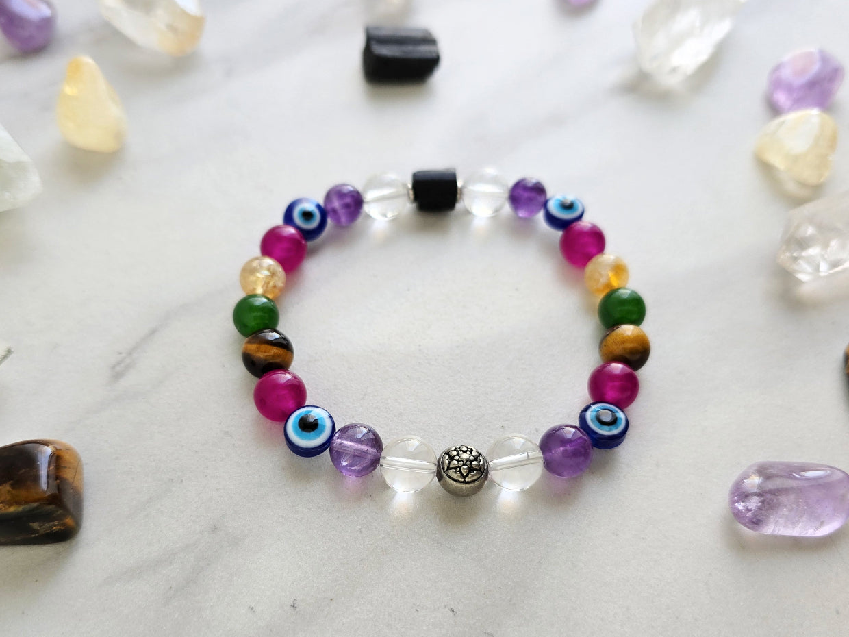 Colorful beaded bracelet on a white surface with crystals and text about collaboration between Ghost Sister and Moxie Malas.