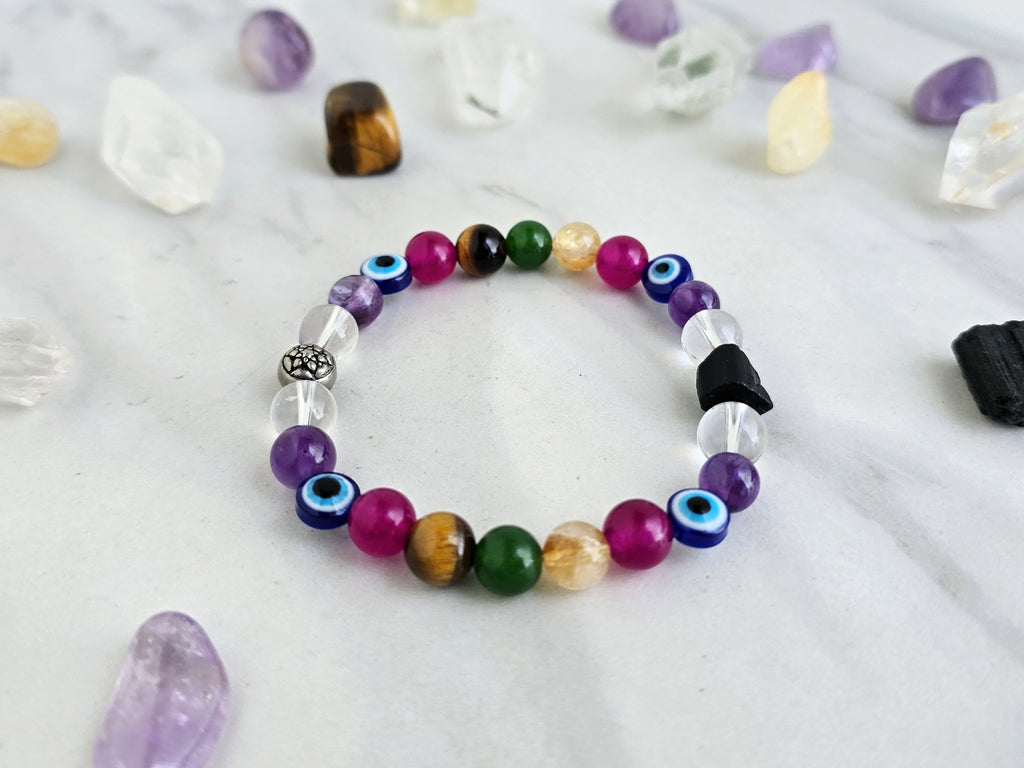 Colorful beaded bracelet on a white surface with crystals and text about collaboration between Ghost Sister and Moxie Malas.