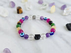 Colorful beaded bracelet on a white surface with crystals and text about collaboration between Ghost Sister and Moxie Malas.