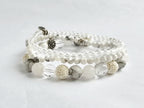 Set of white and gray beaded bracelets on a light gray background