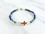 Beaded bracelet with a golden cross on a white marble background, featuring a quote from Proverbs 20:5. Christian Bracelet