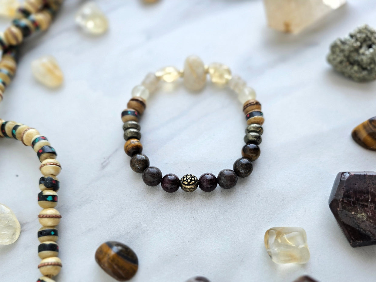 Bracelet with stones and beads on a marble surface with 'Moxie Monthly' branding. planting the seed january 2026 bracelet club