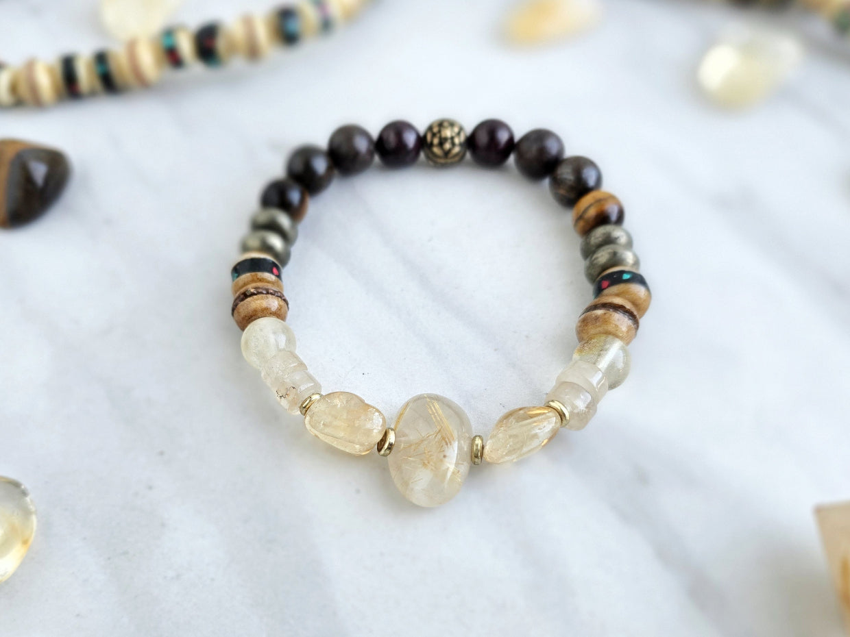 Bracelet with stones and beads on a marble surface with 'Moxie Monthly' branding. planting the seed january 2026 bracelet club