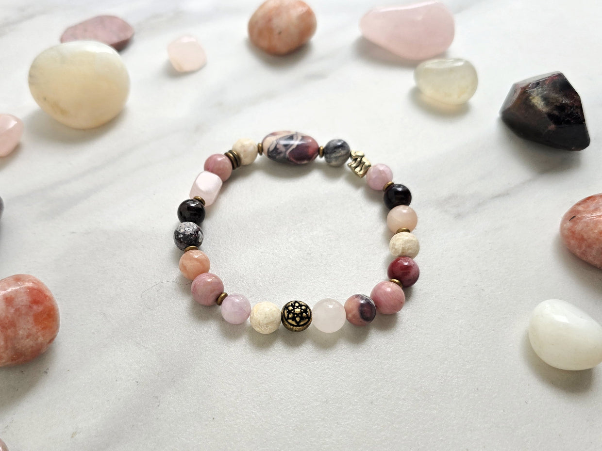 Bracelet with stones on a marble background, featuring 'Moxie Monthly' and 'The Freedom of Forgiveness'. elephant bead moxie monthly bracelet club