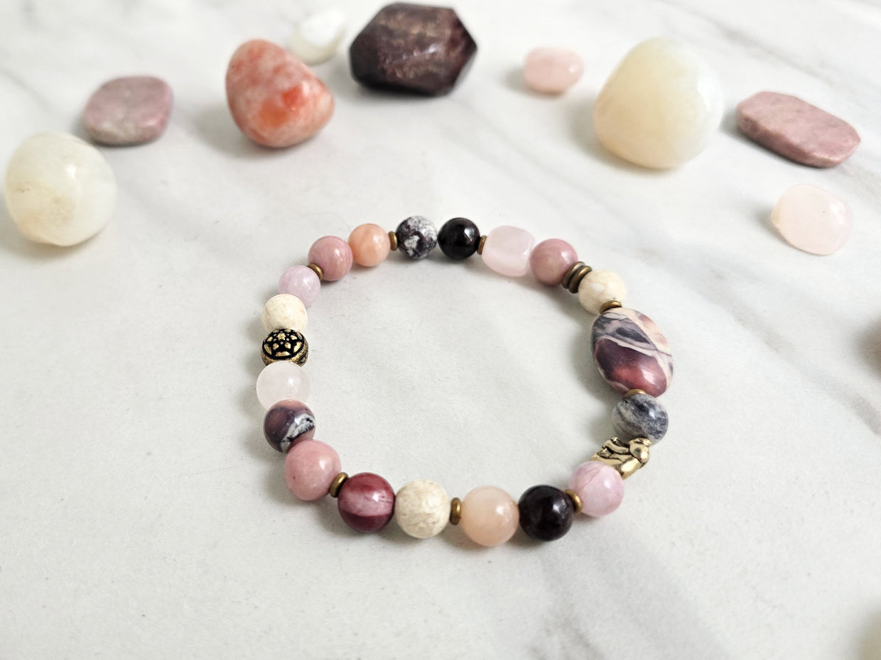 Bracelet with stones on a marble background, featuring 'Moxie Monthly' and 'The Freedom of Forgiveness'. elephant bead moxie monthly bracelet club