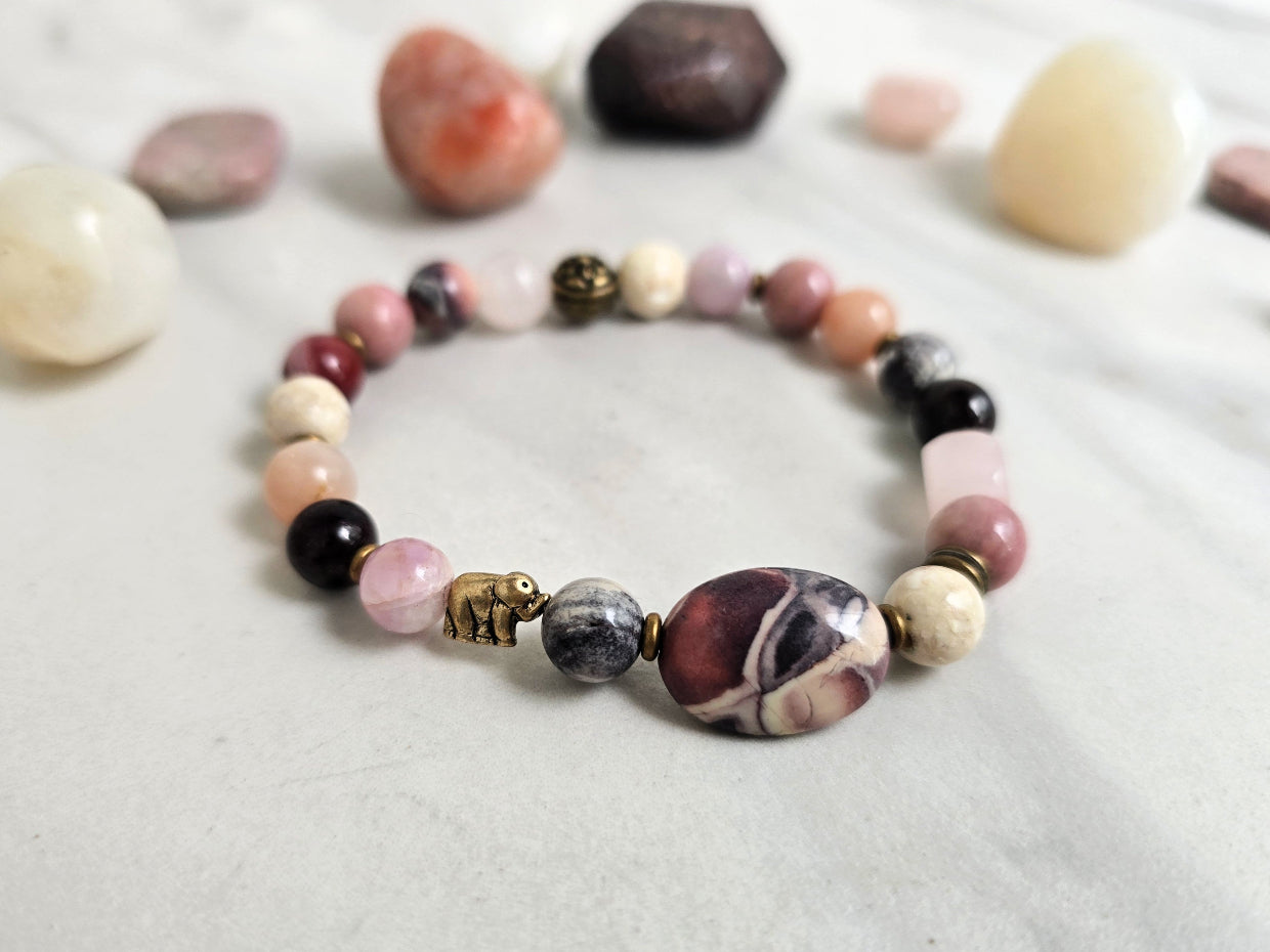 Bracelet with stones on a marble background, featuring 'Moxie Monthly' and 'The Freedom of Forgiveness'. elephant bead moxie monthly bracelet club