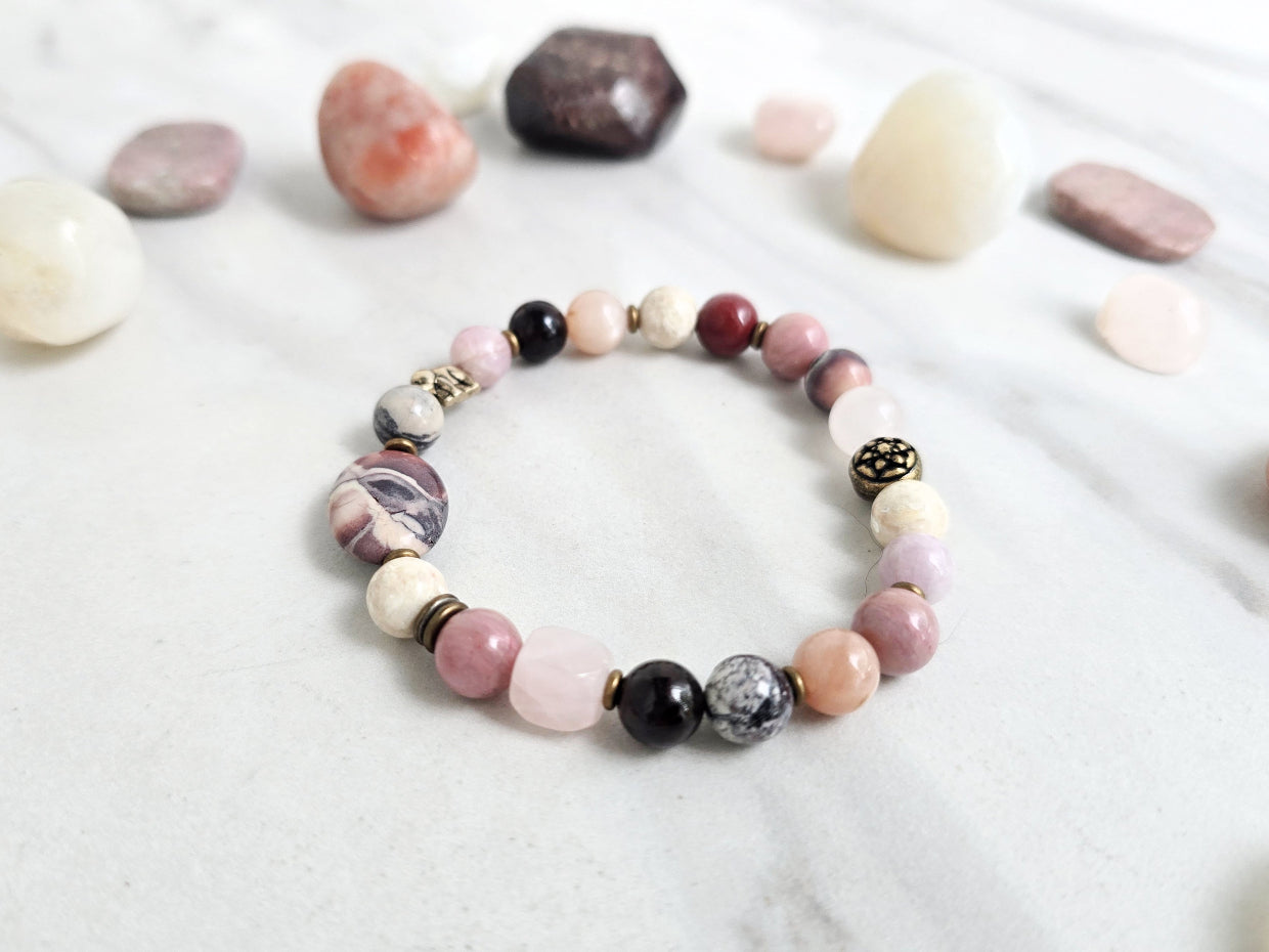 Bracelet with stones on a marble background, featuring 'Moxie Monthly' and 'The Freedom of Forgiveness'. elephant bead moxie monthly bracelet club