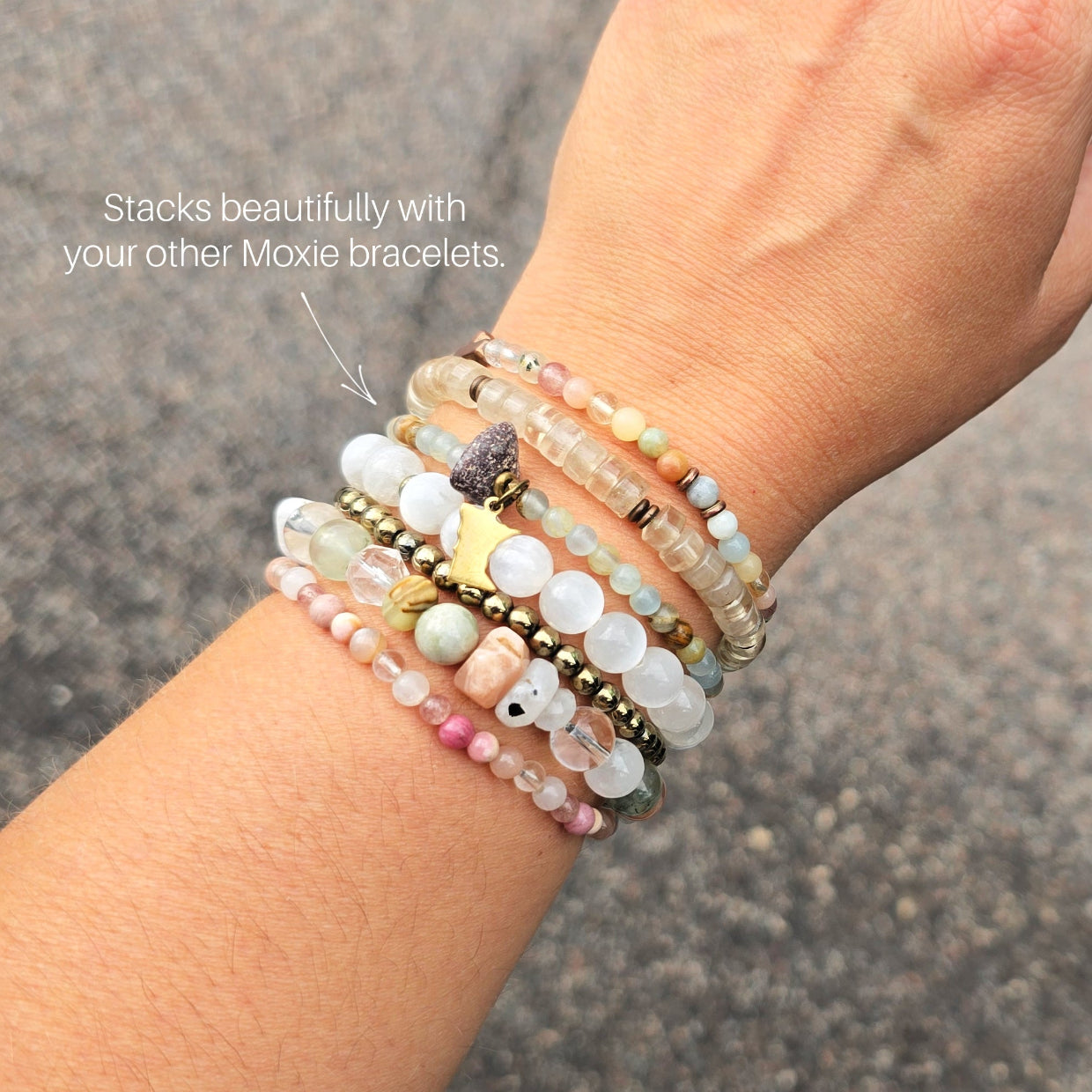 A beaded stretch bracelet featuring light blue-green aquatine calcite beads, brown and cream accent beads, a dark brown bead with a white inlay, a small gold-toned charm, and a gold-toned Minnesota state silhouette charm, displayed on a white marble background with text overlays. MN State Fair Exclusive Moxie Malas