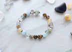 Bracelet with stones on a marble surface, featuring 'Moxie Monthly' march 2026 courage to begin again bracelet club 