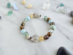 Bracelet with stones on a marble surface, featuring 'Moxie Monthly' march 2026 courage to begin again bracelet club 