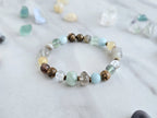 Bracelet with stones on a marble surface, featuring 'Moxie Monthly' march 2026 courage to begin again bracelet club 