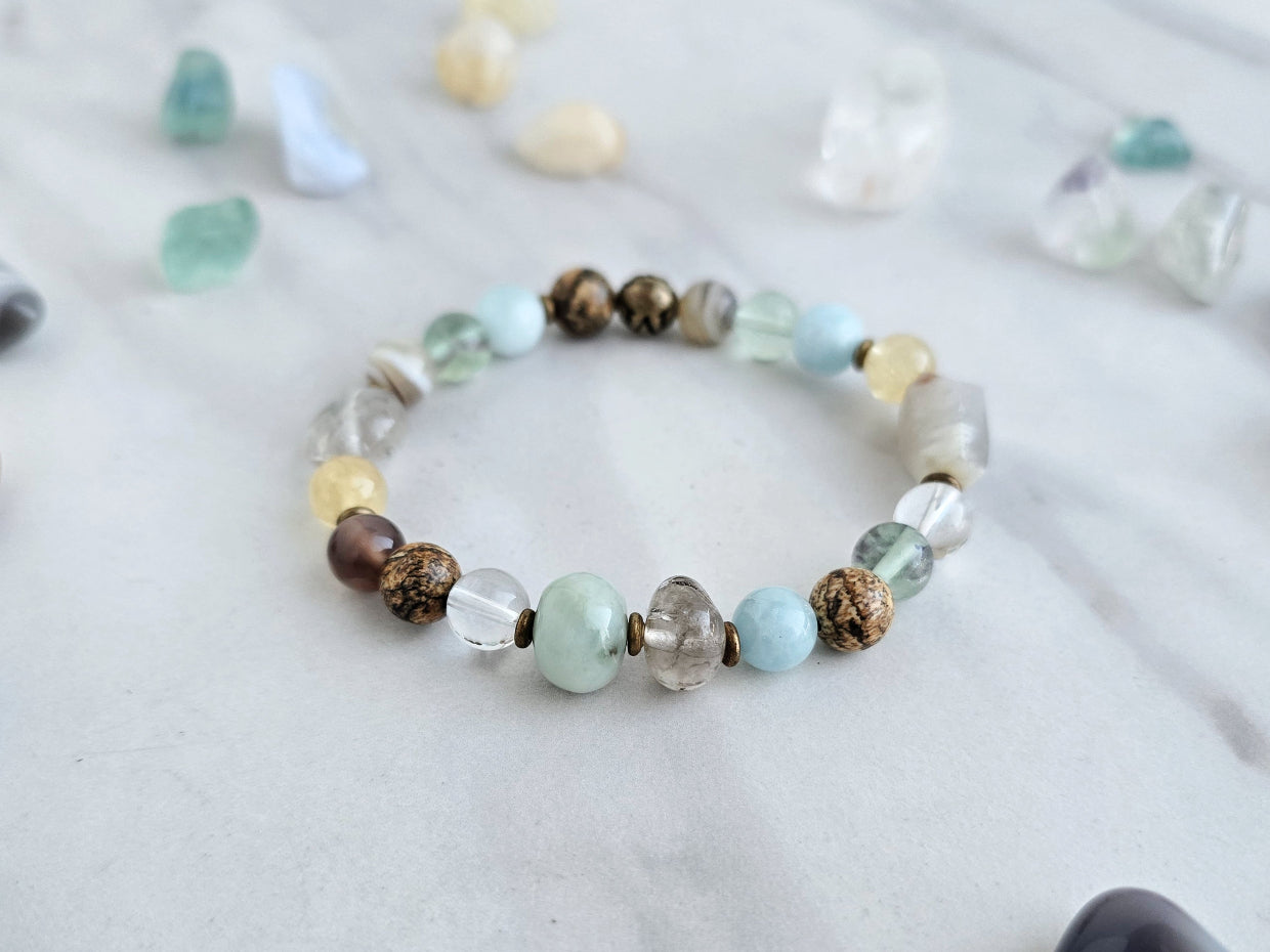 Bracelet with stones on a marble surface, featuring 'Moxie Monthly' march 2026 courage to begin again bracelet club 