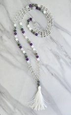 Beaded necklace with a tassel on a marble surface metatron meditation beads mala