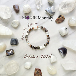 Bracelet with stones on a marble surface, featuring 'MOXIE Monthly' branding. open to receive brown white copper colors
