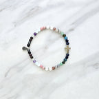 multi color crystal and stone Christian bracelet on a white marble background john 14:27 peace i give you