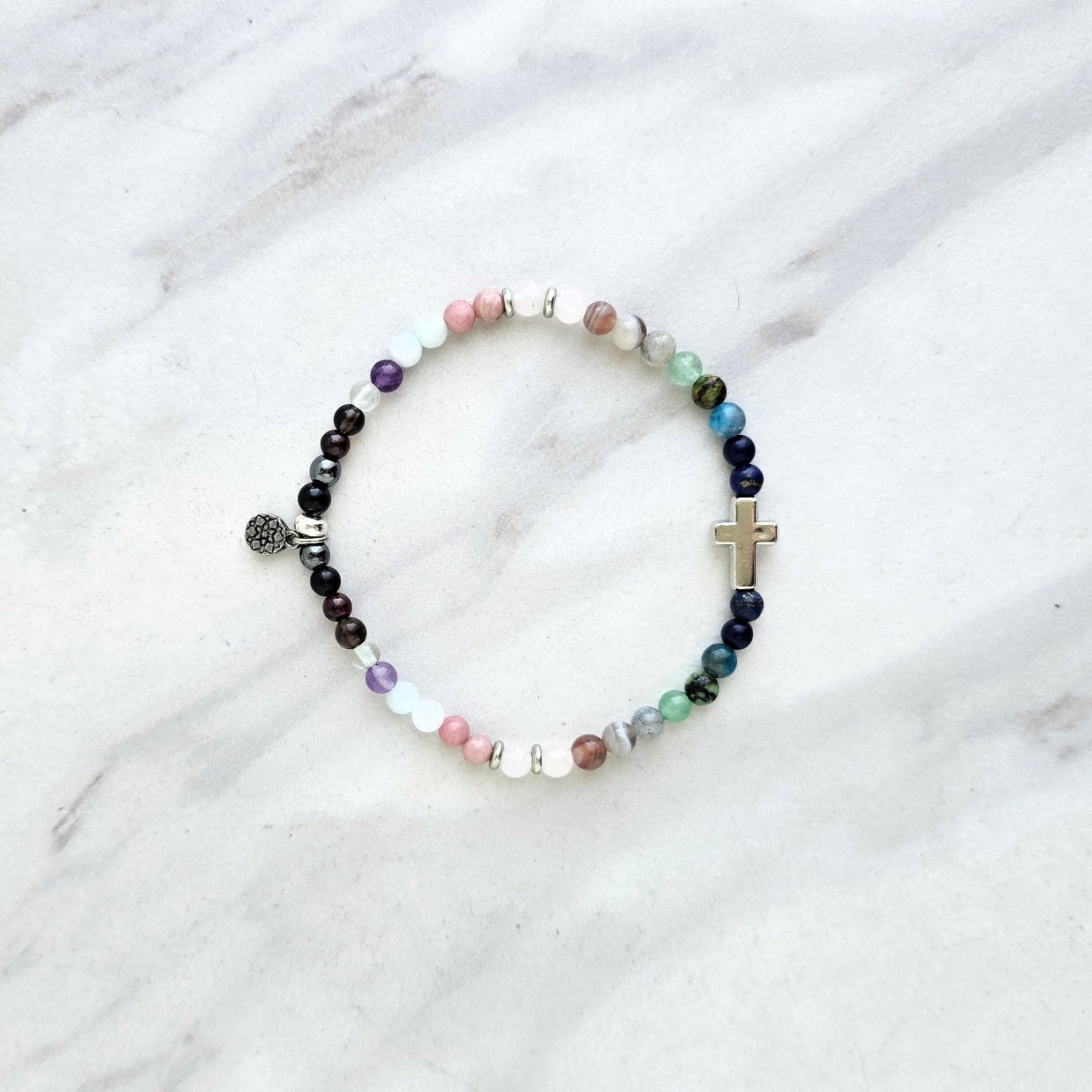 multi color crystal and stone Christian bracelet on a white marble background john 14:27 peace i give you
