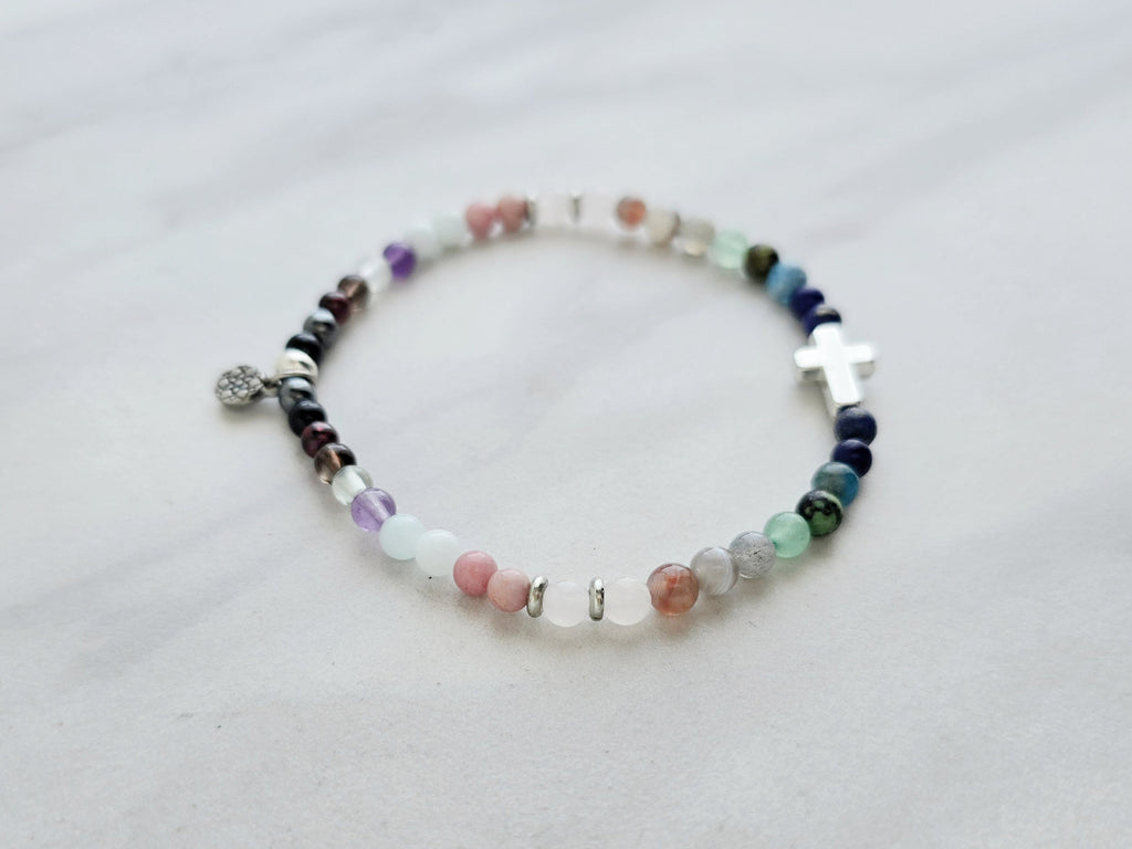 multi color crystal and stone Christian bracelet on a white marble background john 14:27 peace i give you