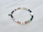 multi color crystal and stone Christian bracelet on a white marble background john 14:27 peace i give you