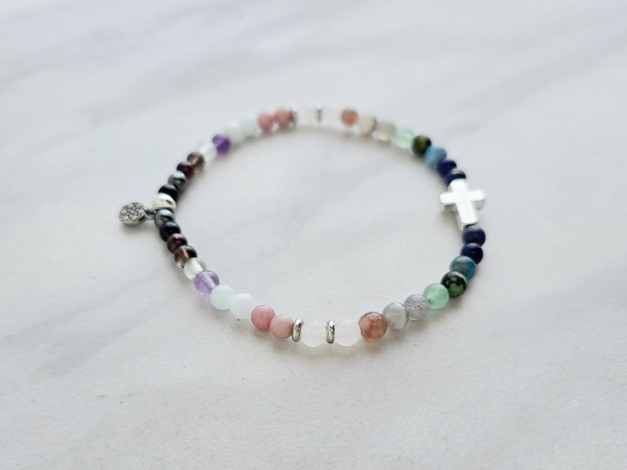 multi color crystal and stone Christian bracelet on a white marble background john 14:27 peace i give you