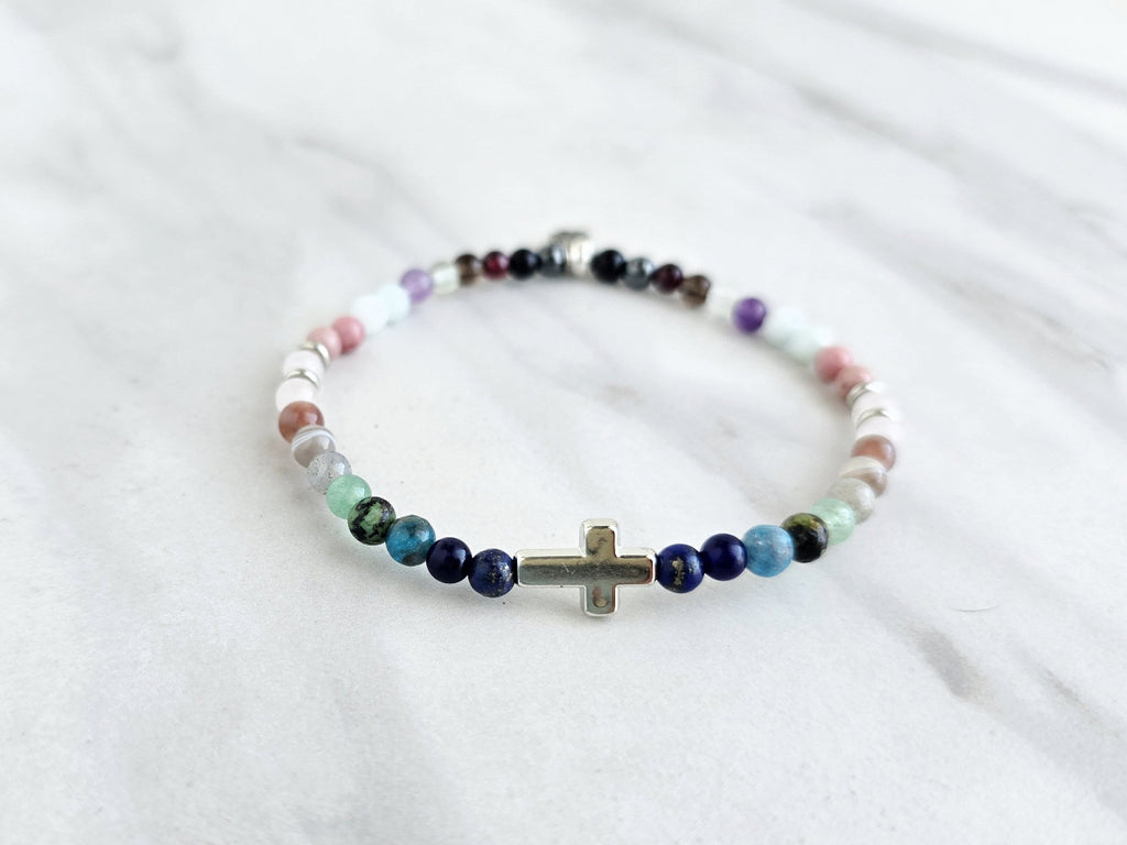 multi color crystal and stone Christian bracelet on a white marble background john 14:27 peace i give you