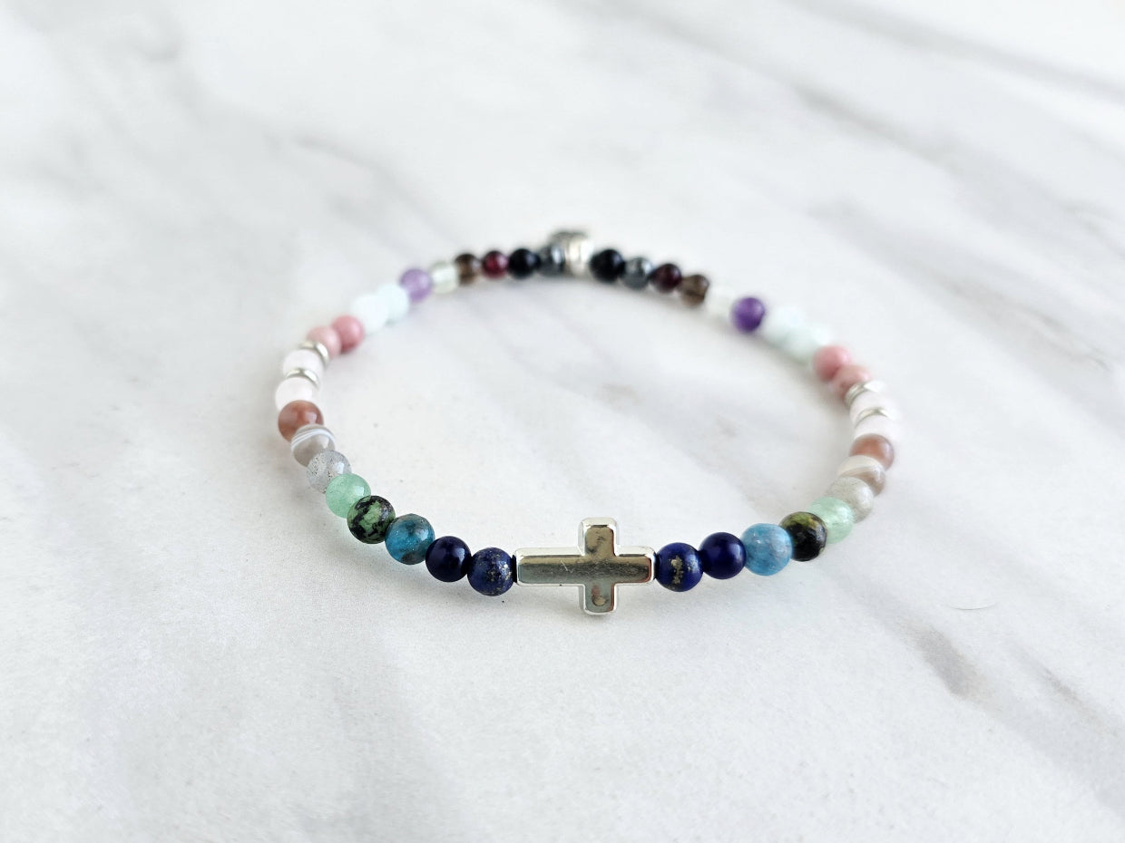 multi color crystal and stone Christian bracelet on a white marble background john 14:27 peace i give you