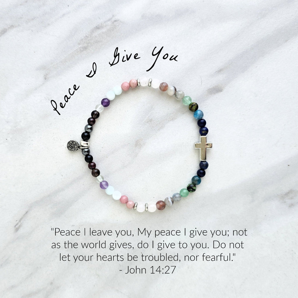 multi color crystal and stone Christian bracelet on a white marble background john 14:27 peace i give you