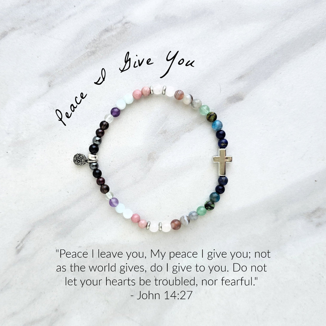 multi color crystal and stone Christian bracelet on a white marble background john 14:27 peace i give you