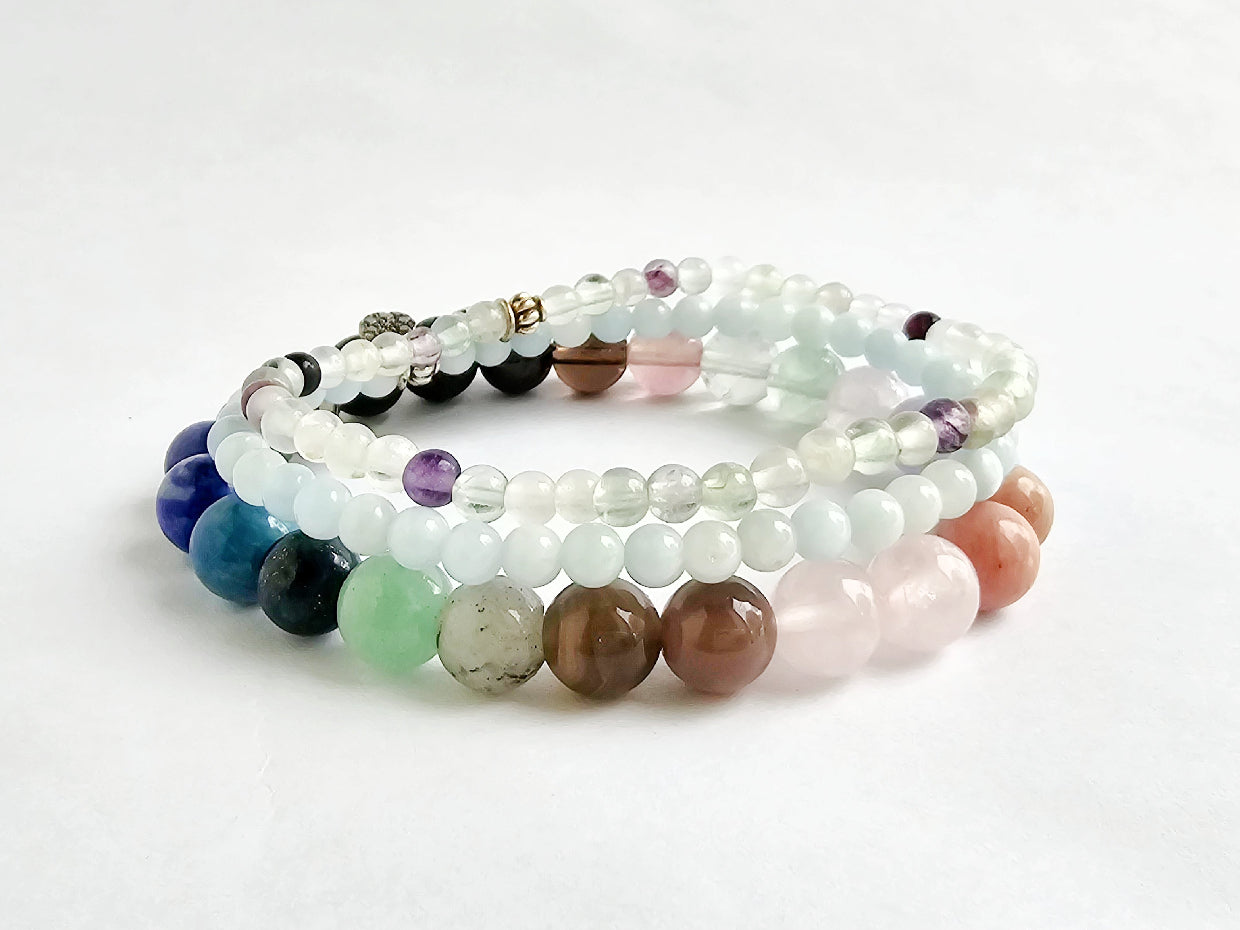 Stack of multicolored beaded bracelets on a white background