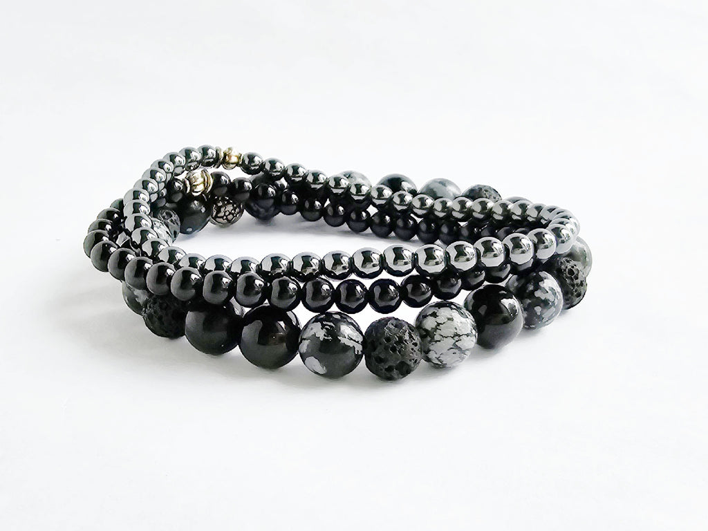 Set of black beaded bracelets on a white background