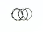 Three black beaded bracelets on a white background