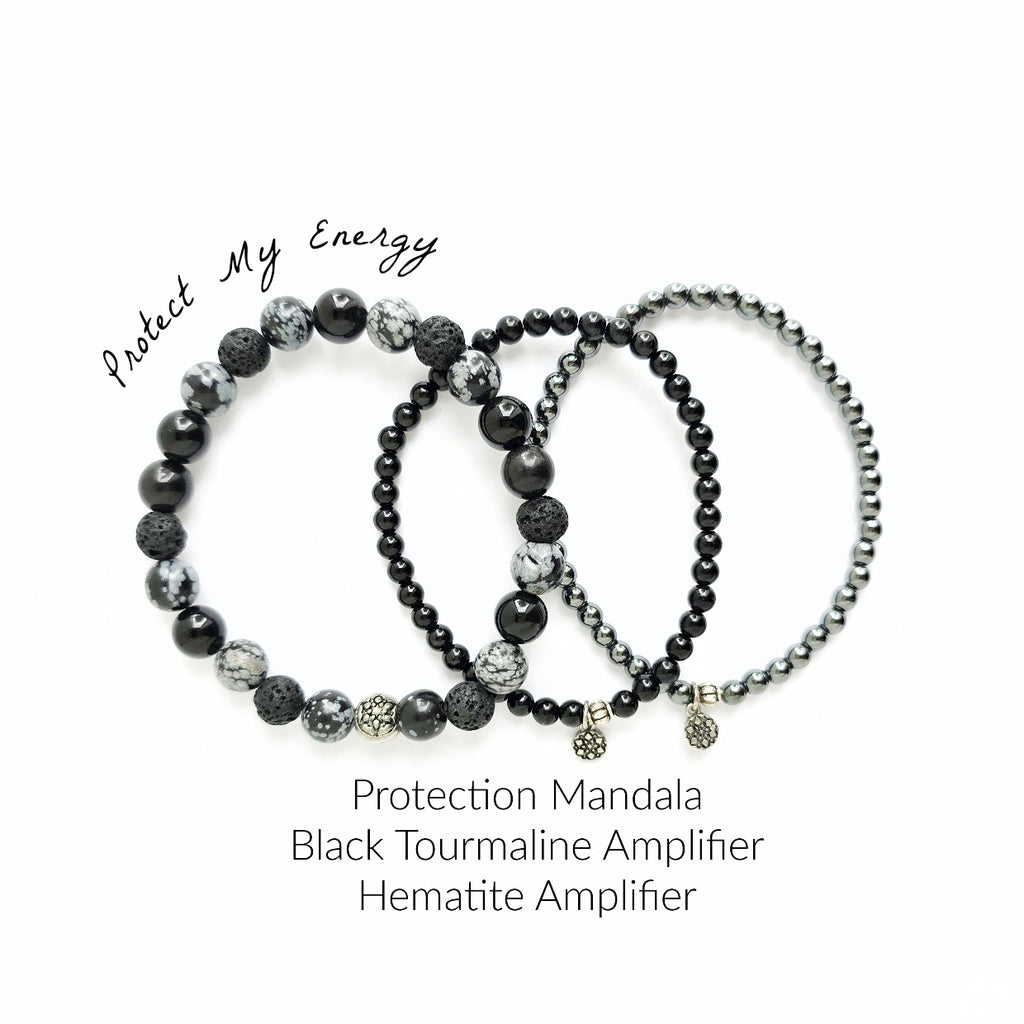 Set of black beaded bracelets with text on a white background