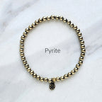 Pyrite bracelet on a marble surface with 'Pyrite' text.