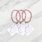 Three pink rhodonite beaded bracelets on cards with 'Rhodonite' text, branded 'Rhodonite Bestie Bundles' on a marble background. valentine gifts galentines day