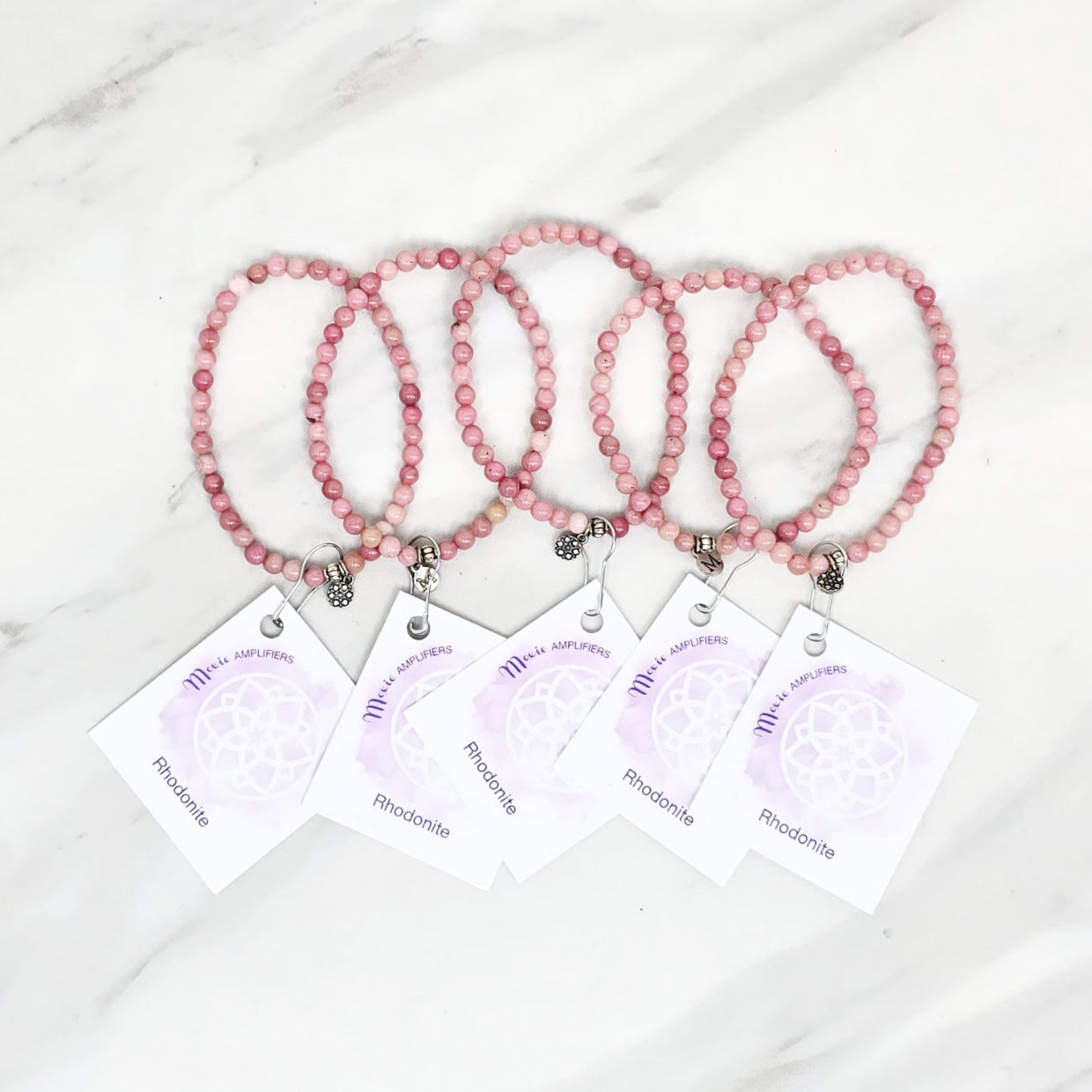 Three pink rhodonite beaded bracelets on cards with 'Rhodonite' text, branded 'Rhodonite Bestie Bundles' on a marble background. valentine gifts galentines day
