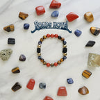 Colorful beaded bracelet on a marble surface with various stones and 'Roads Hotel' branding.