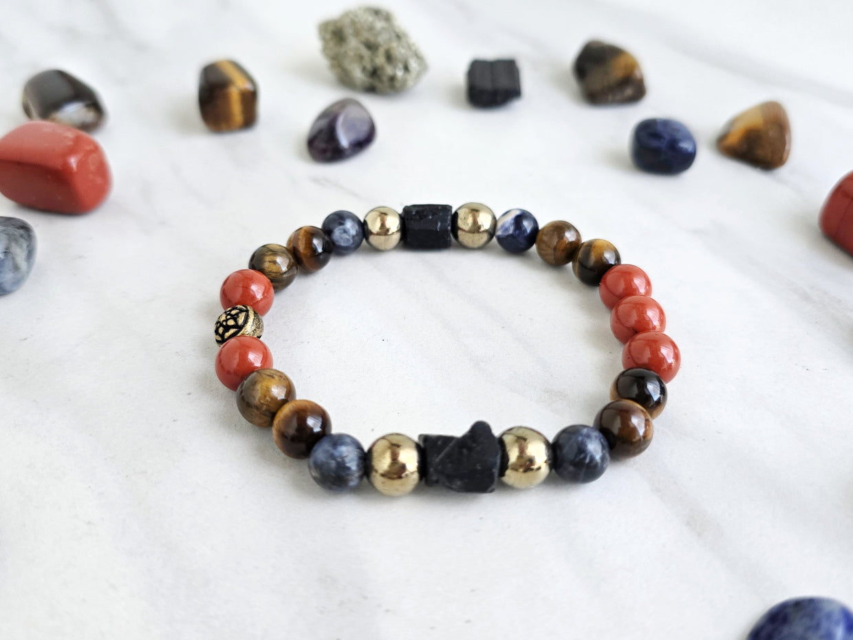 Colorful beaded bracelet on a marble surface with various stones and 'Roads Hotel' branding.