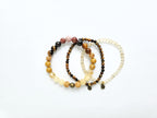 Set of three beaded bracelets on a white background